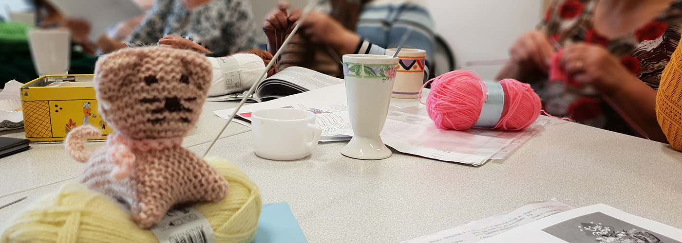 Cercle de femmes tricotant accompagné d'une tasse de café chacune